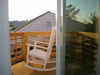 a rocking chair on a sunny balcony